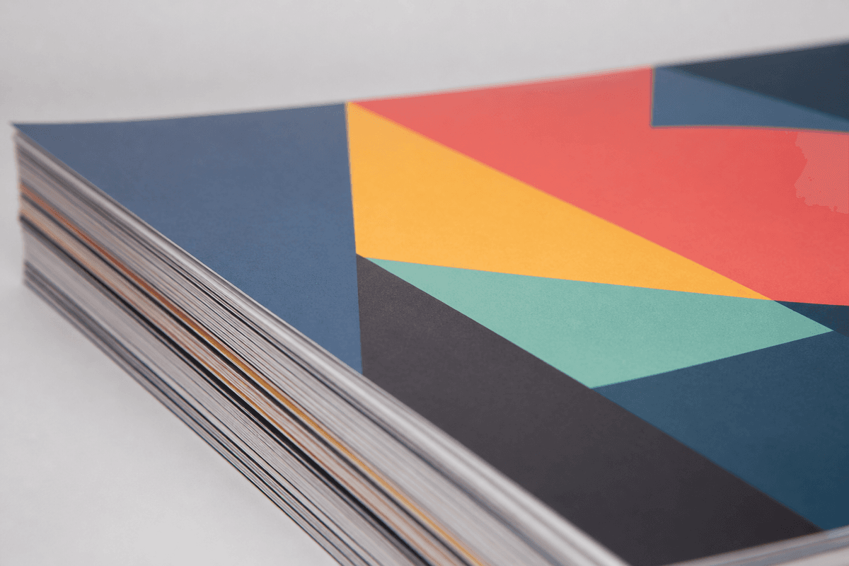 Close-up of a stack of large-format posters with a matte laminated surface under soft studio lighting