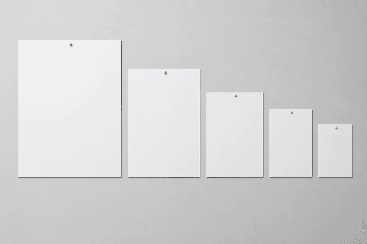 Blank posters in graduated A-series sizes arranged largest to smallest on a neutral wall