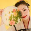 Woman Wearing a Kimono and Red Lipstick Holding a Floral Hand Fan