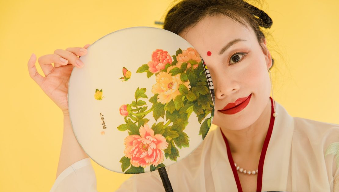 Woman Wearing a Kimono and Red Lipstick Holding a Floral Hand Fan
