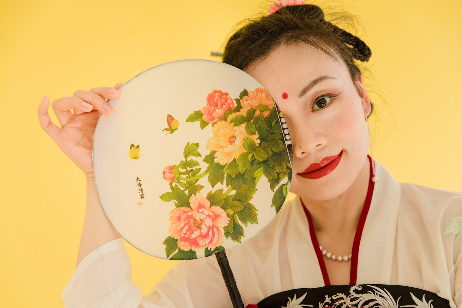 Woman Wearing a Kimono and Red Lipstick Holding a Floral Hand Fan