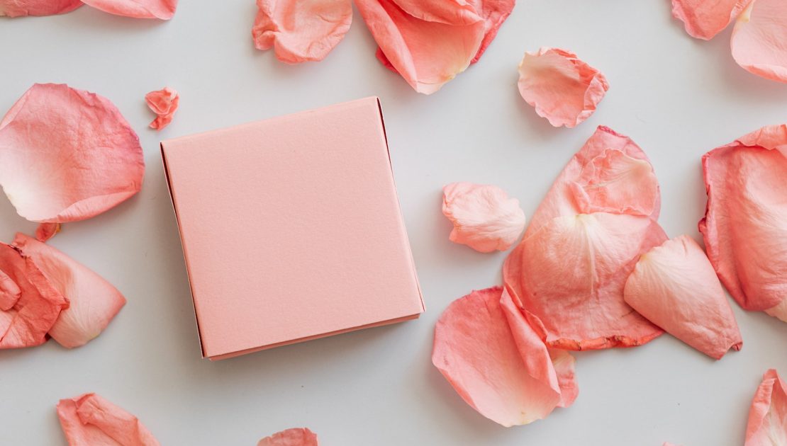 Gift in pink box with scattered petals around