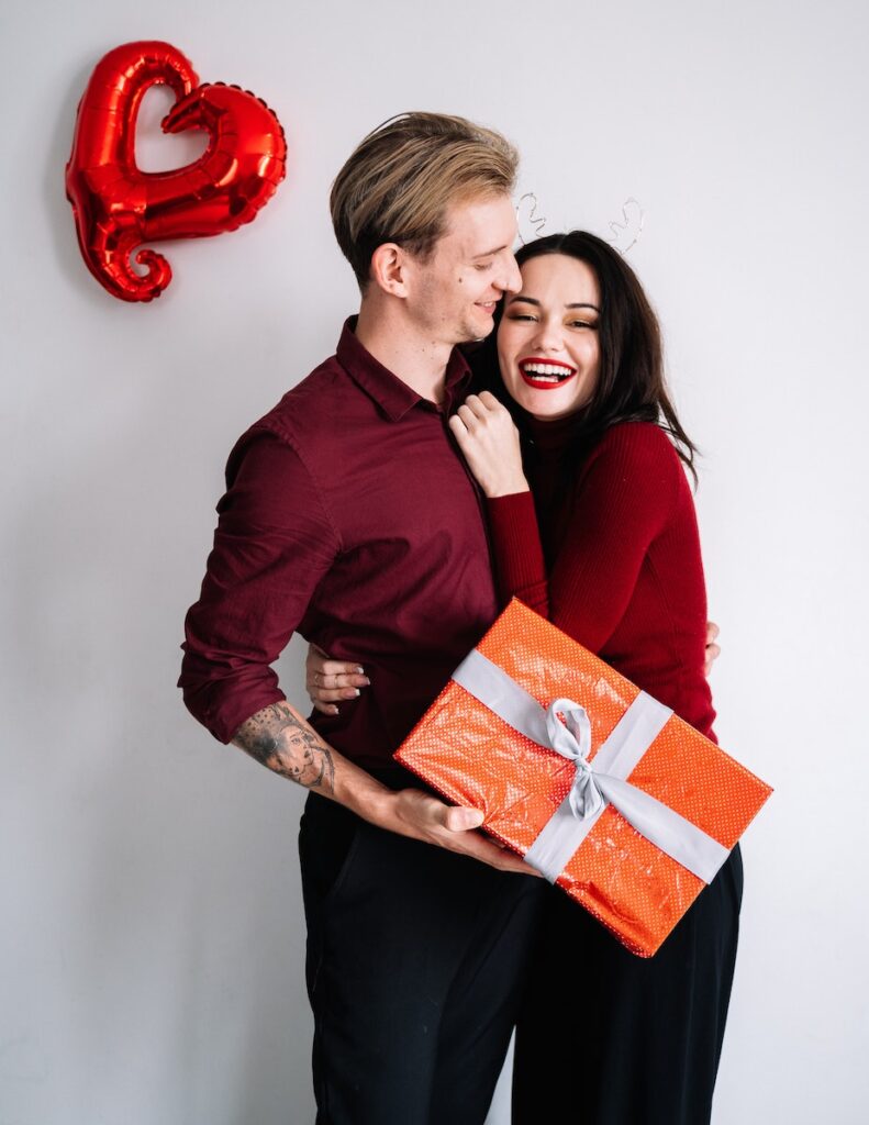 A Man Holding a Gift Box Near a Woman