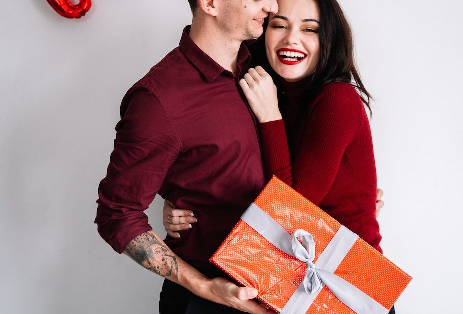 A Man Holding a Gift Box Near a Woman