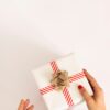 person holding white and red gift box