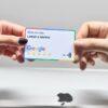 two hands holding a google credit card in front of an apple logo
