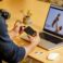 A man sitting at a table with a laptop and cell phone