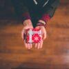 person holding red and white box