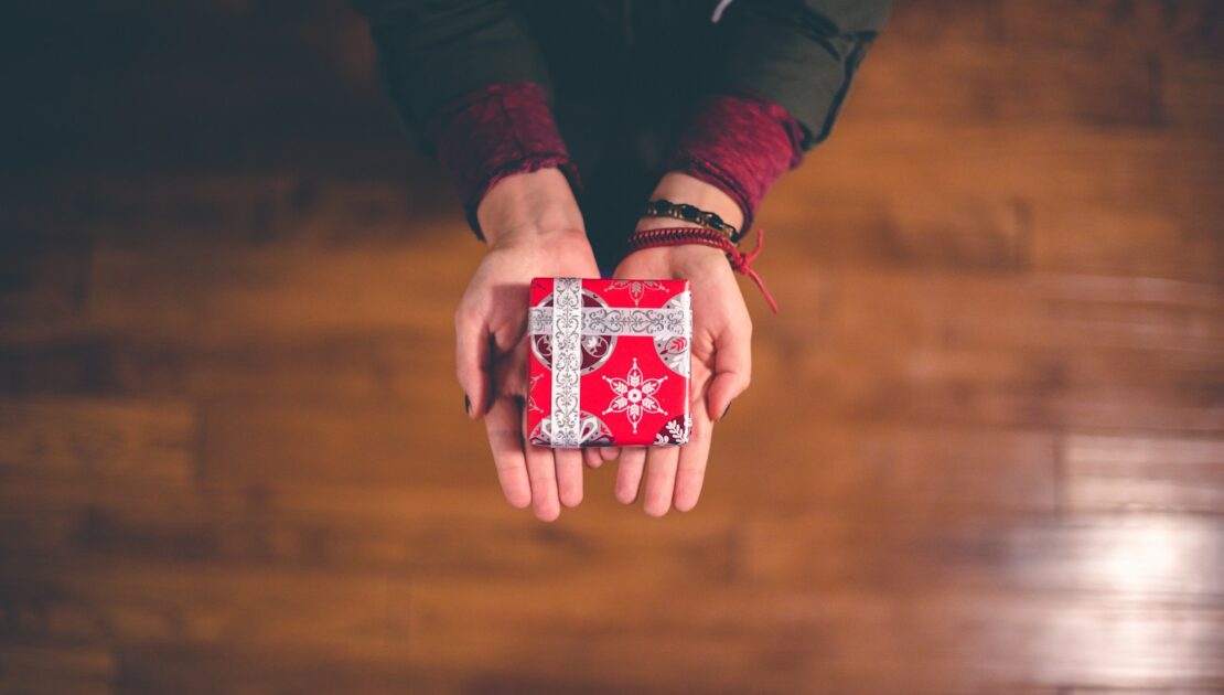 person holding red and white box